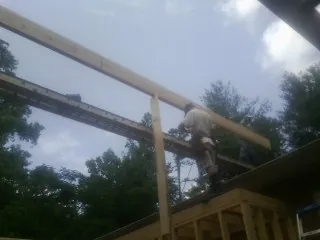 Carpenter setting a ridge beam over a new addition frame — Ice Dam Removal by Roofing Brothers in Momence