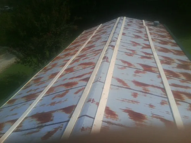 Rusted metal roof panels with new wood purlins before replacement — Storm Damage Roof Repair in Momence by Roofing Brothers