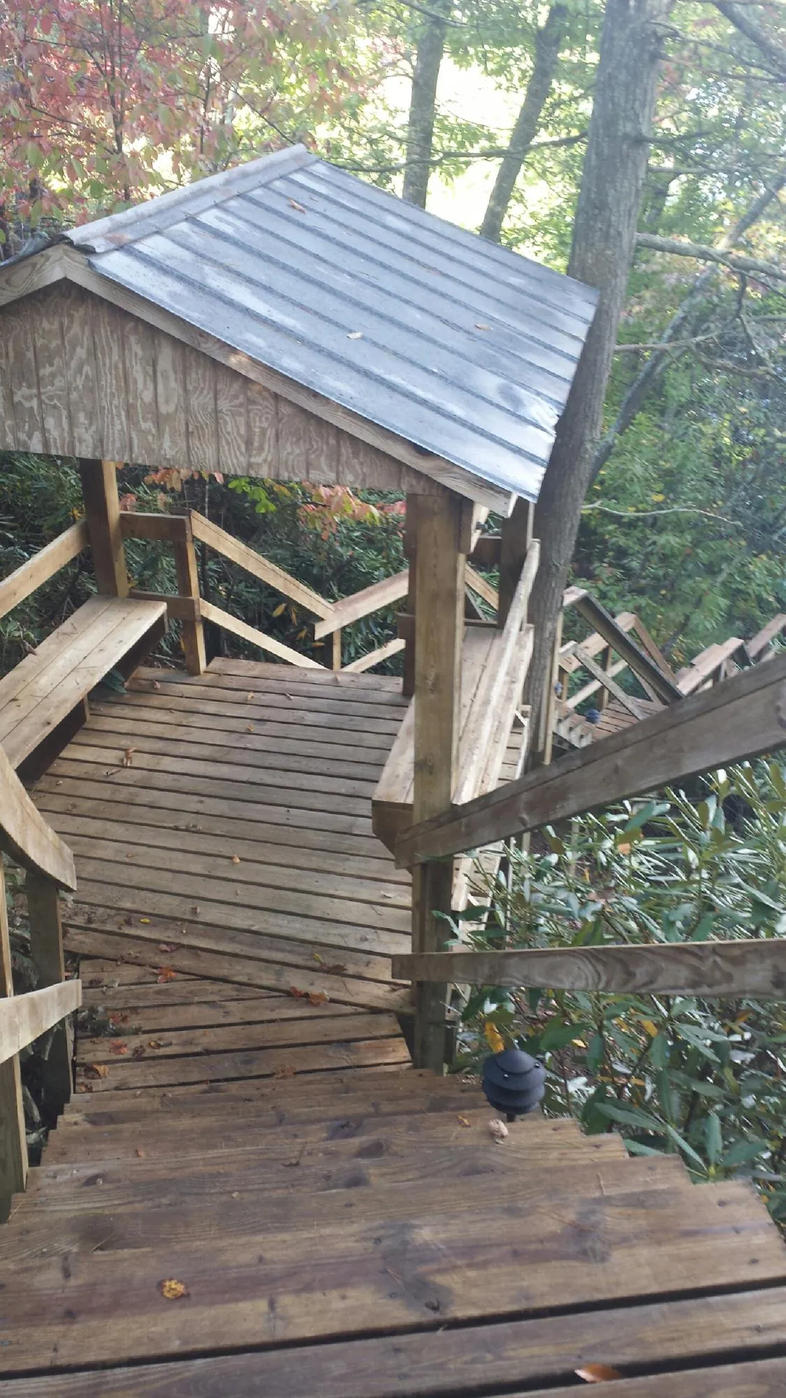 Metal roofed shelter over wooden steps on a wooded walkway — Skylight Repair & Installation work by our crew in Momence