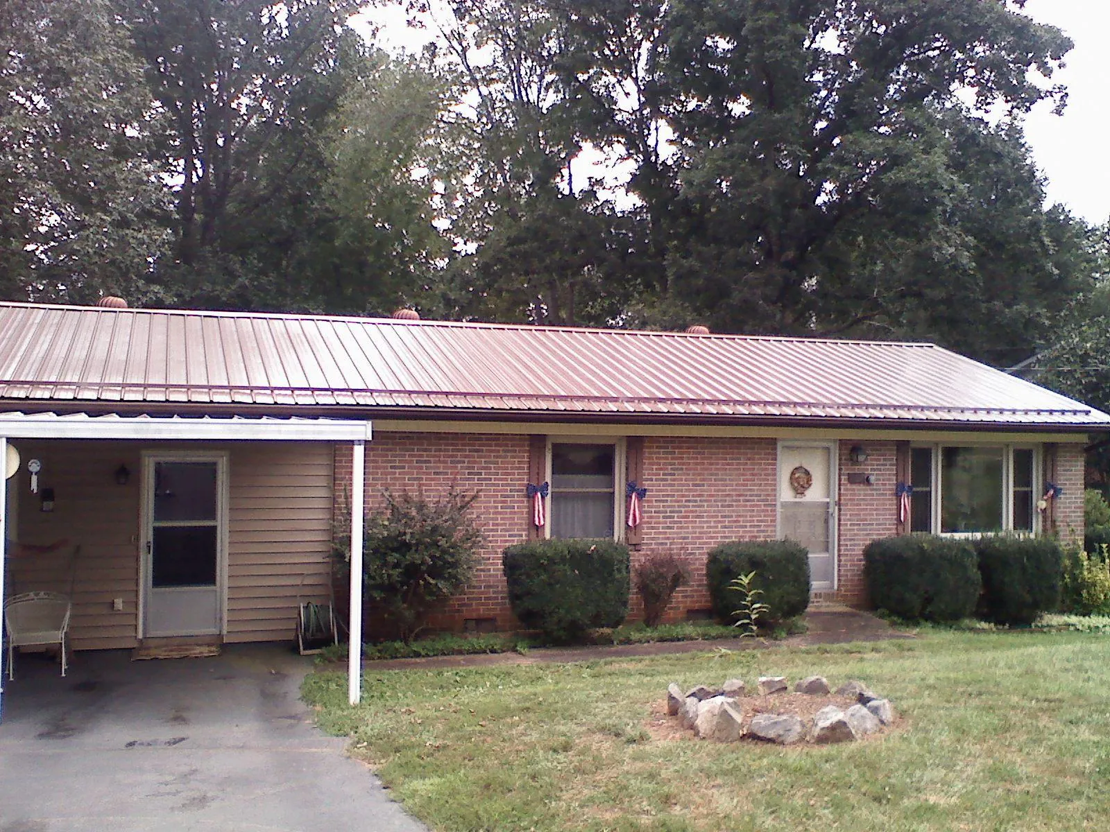 Bronze metal roof and carport on a brick ranch home — Roof Repair work by our crew in Momence